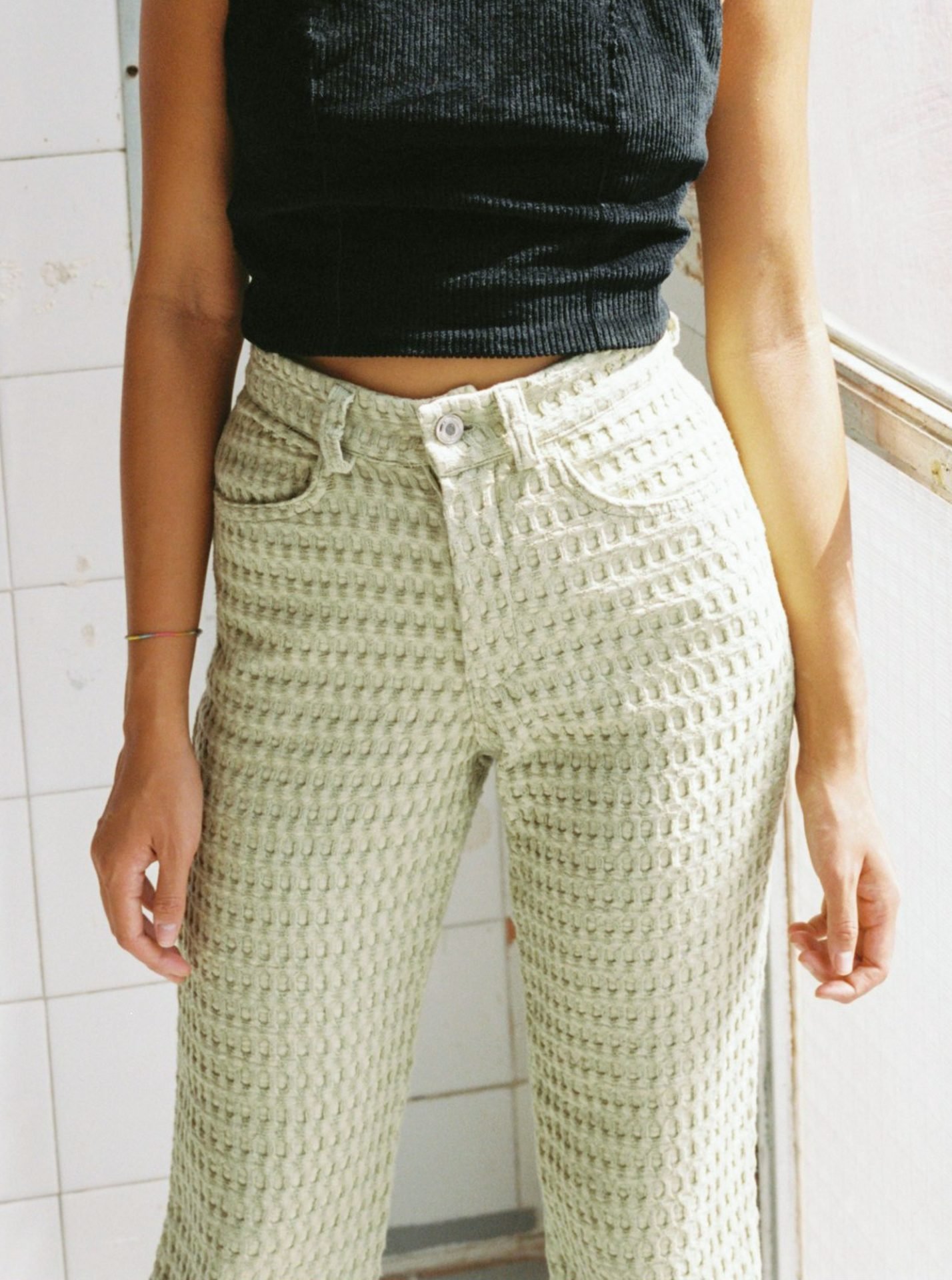 High-waisted waffle trousers with a straight leg, back pockets, belt loops, metal zip, and vintage button closure. Made from deadstock organic cotton waffle fabric. Made in Barcelona. 100% Organic Cotton.
